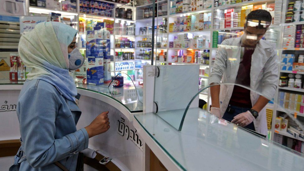 A woman wearing a protective mask shops at a pharmacy in Tehran, Iran (24 February 2020)