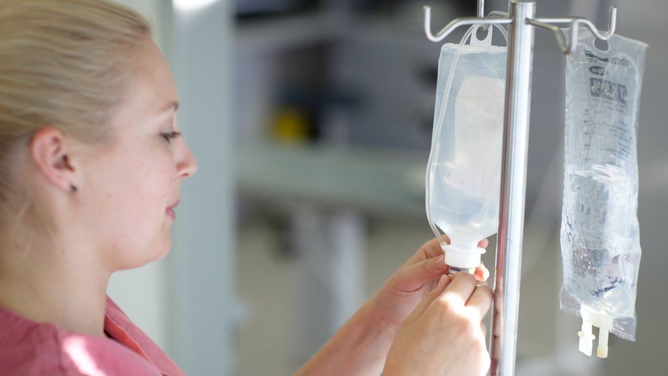 A woman preparing an IV drip