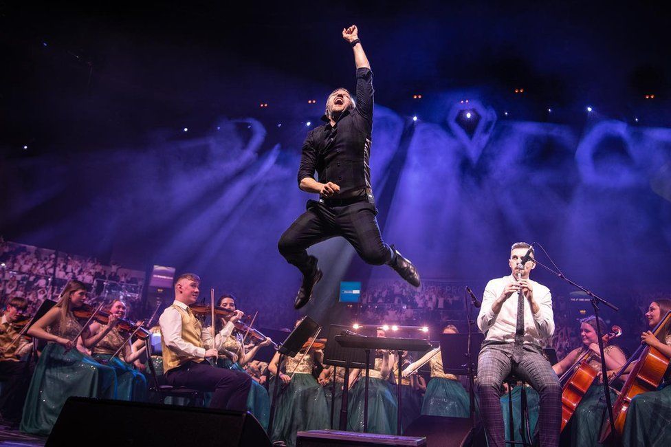 Conductor Greg Beardsell leaps in the air as the Cross-Border Orchestra of Ireland perform behind him