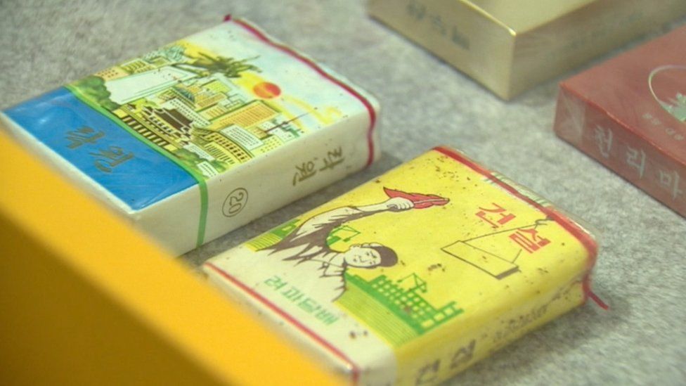 Cigarette cases. ‘Paradise(left)’ and ‘Establishment(right)’. Tobacco smoking is very popular among North Korean men.