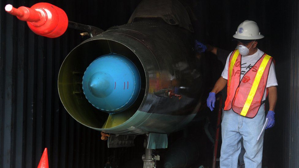 A man next to a MIG-21 fighter jet found in a container on board the Chong Chon Gang, a North Korean ship.