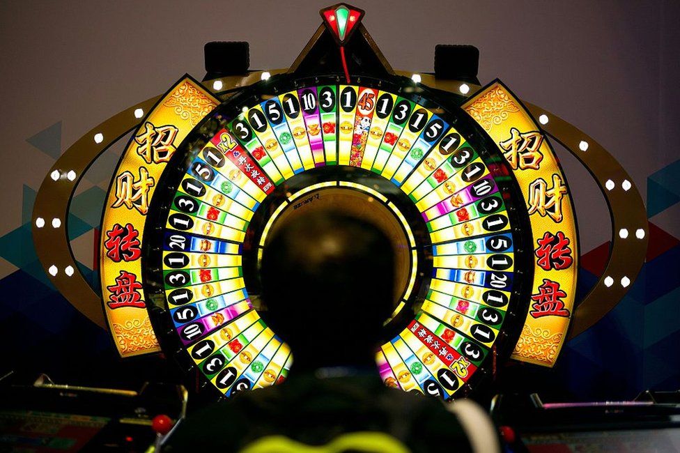A man tries his luck at a wheel of fortune machine