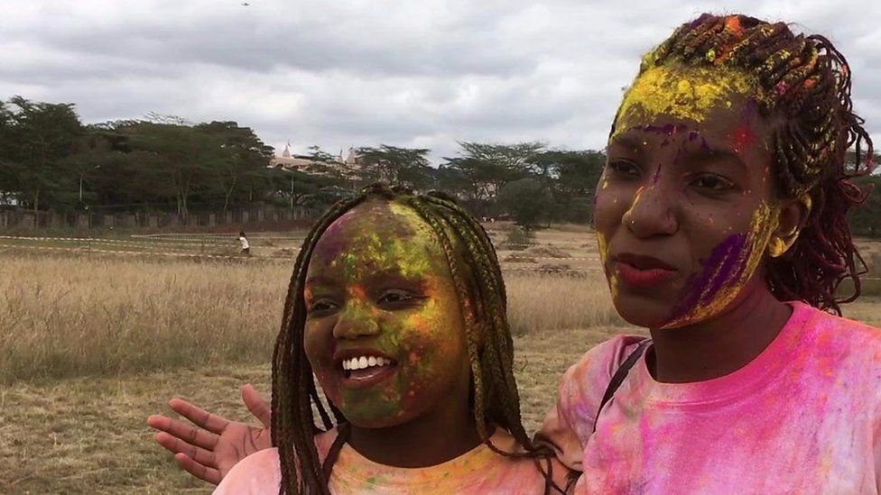 Two young women covered in coloured powder at the run
