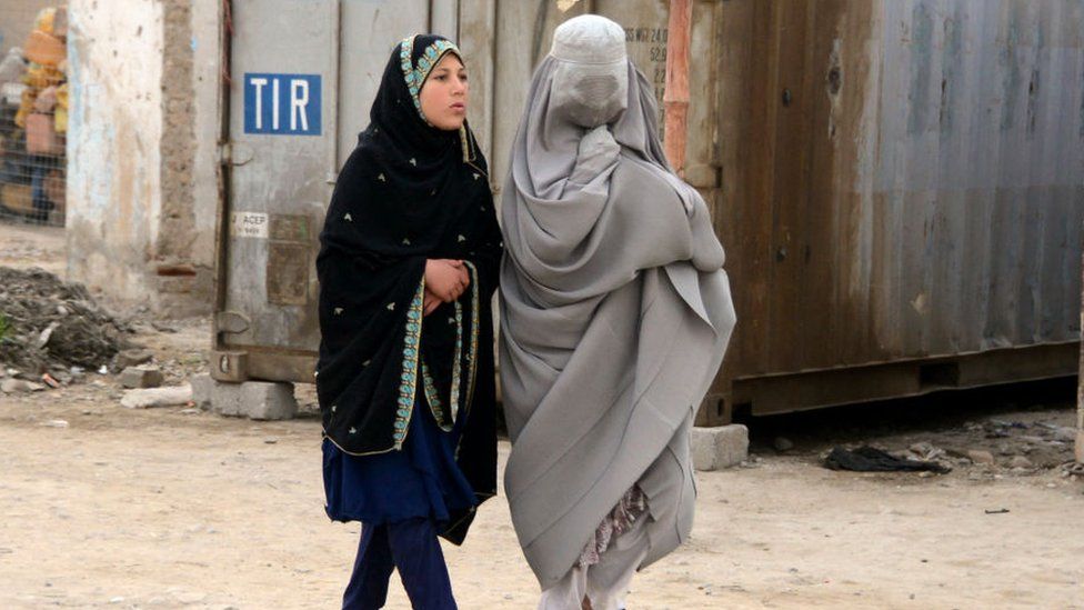 A burka-clad woman and a girl on a street in Kandahar on 5 March 2022