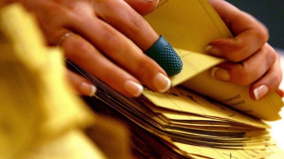 Close up of a woman counting ballot papers