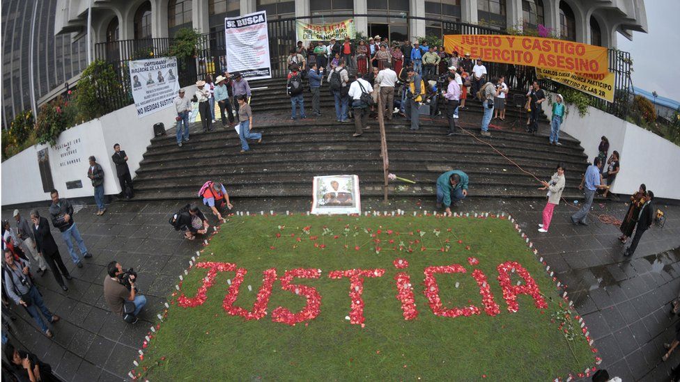 Relatives of the victims of the slaughter of the villa Dos Erres form the word 'Justice' with flowers outside the Supreme Court on August 2, 2011 in Guatemala City before the trial of military men involved.