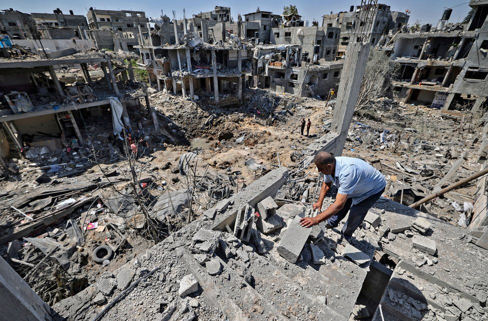 Palestinians assess the damage caused by Israeli air strikes, in Beit Hanun in the northern Gaza Strip, on May 14, 2021.
