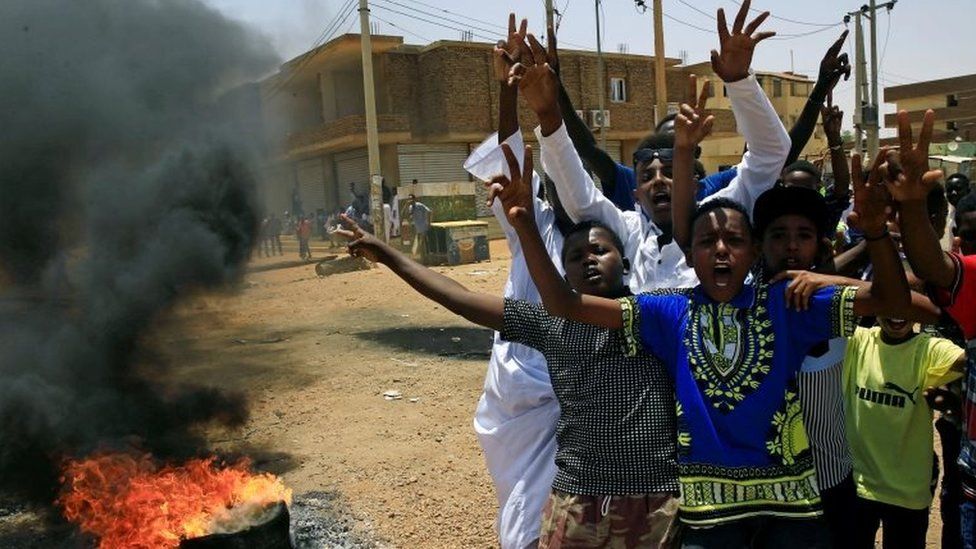 Sudanese protesters gesture and chant slogans at a barricade along a street, demanding that the country's Transitional Military Council hand over power to civilians, in Khartoum, Sudan on 5 June 2019