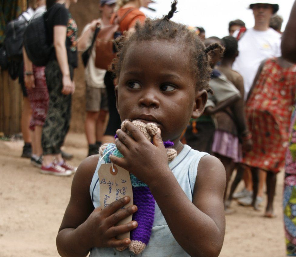 Child in Africa with knitted teddy