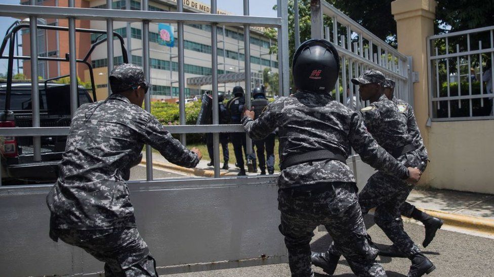 Police scramble to enter the ministerial premises after a friend of Orlando Jorge Mera shot and killed him in his office