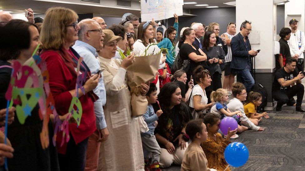 Семьи ждут воссоединения, когда путешественники прибывают первым рейсом из Сиднея,
