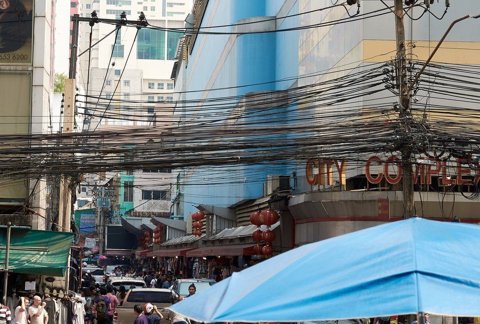A mass of communication and power cables strung above the street keeping the city connected