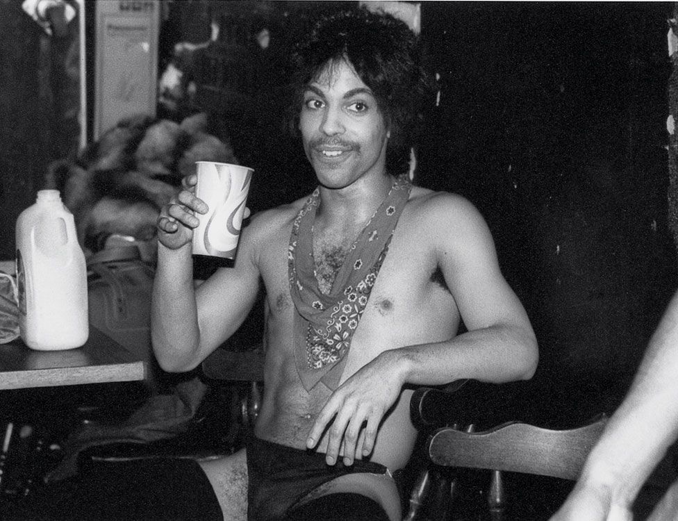 Prince sips some orange juice backstage during the Dirty Mind tour, 1981