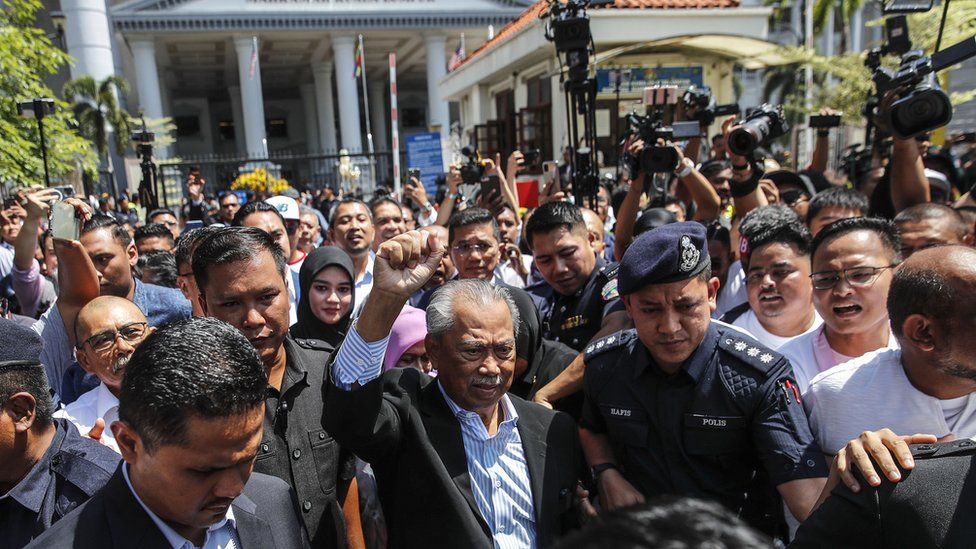 前总理穆希丁亚辛在周五的听证会后离开吉隆坡法院时被媒体和人群包围