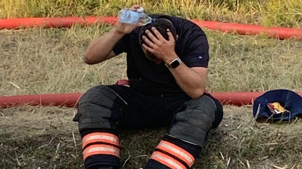 Fireman pouring water on his head