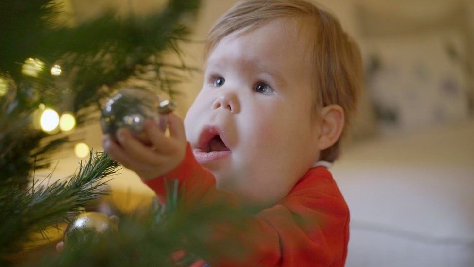 Finley looking at a bauble on a christmas tree