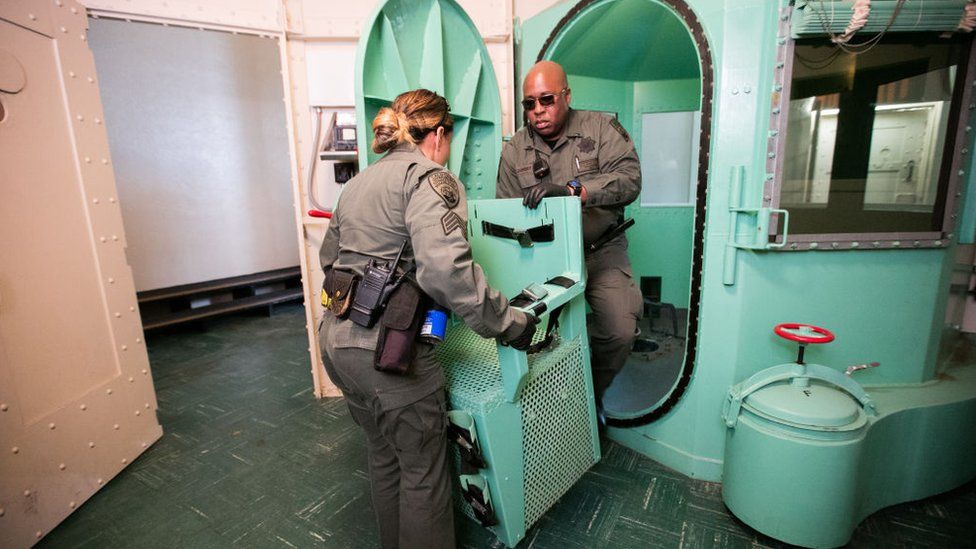 Workers remove a chair from a gas chamber at San Quentin