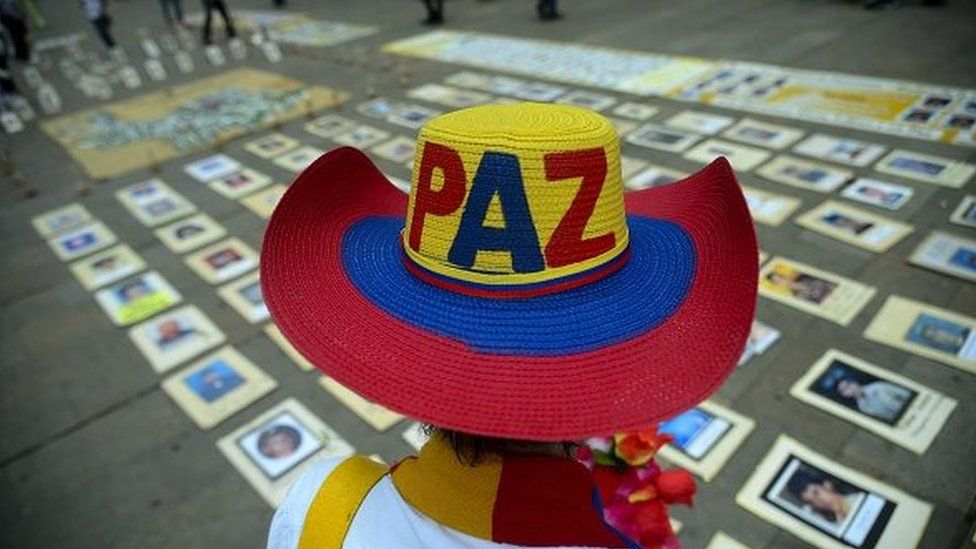 A person wearing a hat which says "Paz" (peace) attends a commemoration for victims of the armed conflict in Colombia