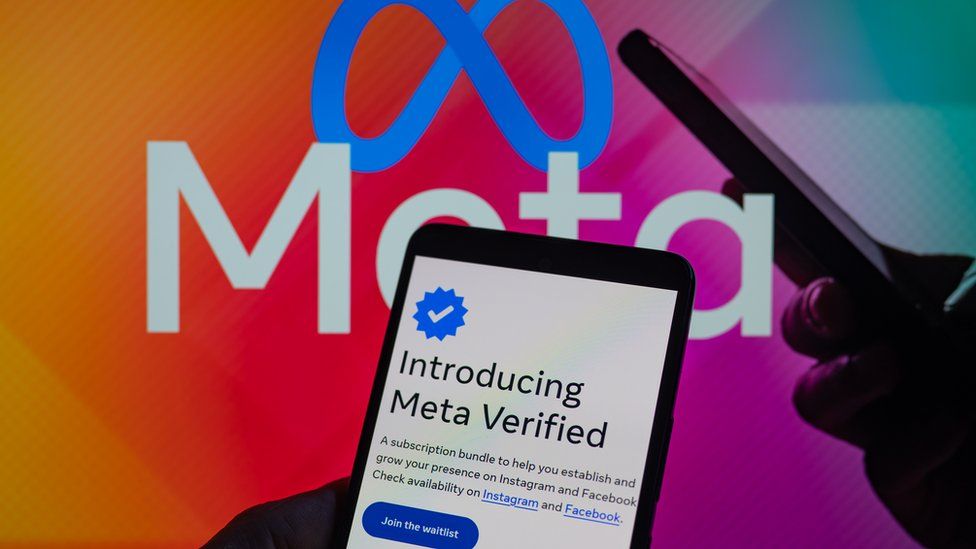 A mobile phone with meta verification in front of the meta logo