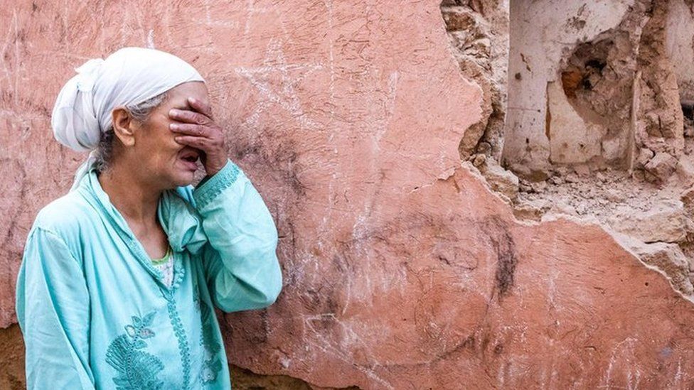 A woman standing in front of her earthquake-damaged home in Marrakesh on 9 September