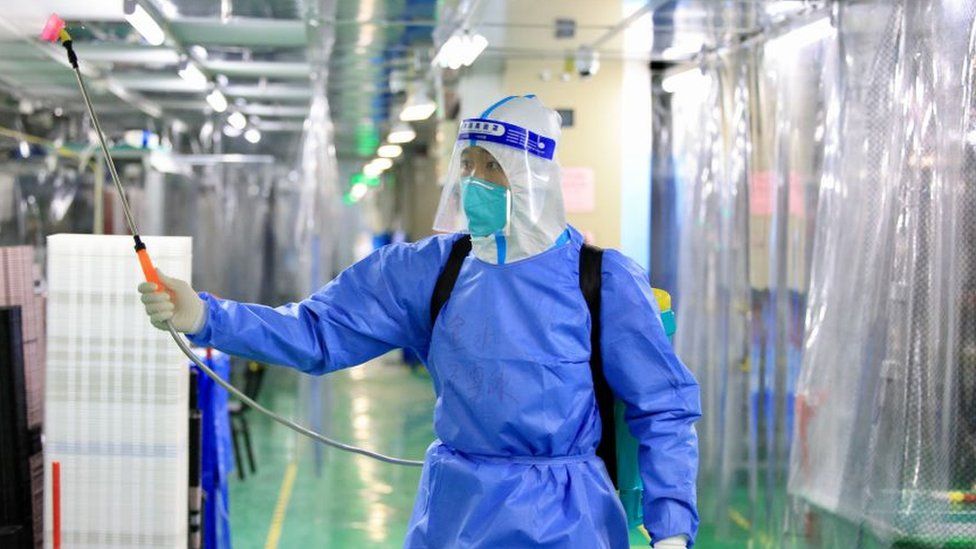 Рабочий в средствах индивидуальной защиты дезинфицирует завод Foxconn в Чжэнчжоу, Китай, ноябрь 2022 года.