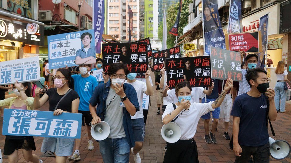 Candidates march on a street to campaign for the primary elections in Hong Kong
