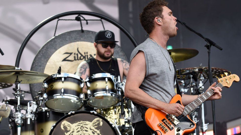 Royal Blood on stage, Ben Thatcher, left, is playing the drums, and Mike Kerr, right, is singing in to a microphone while playing guitar