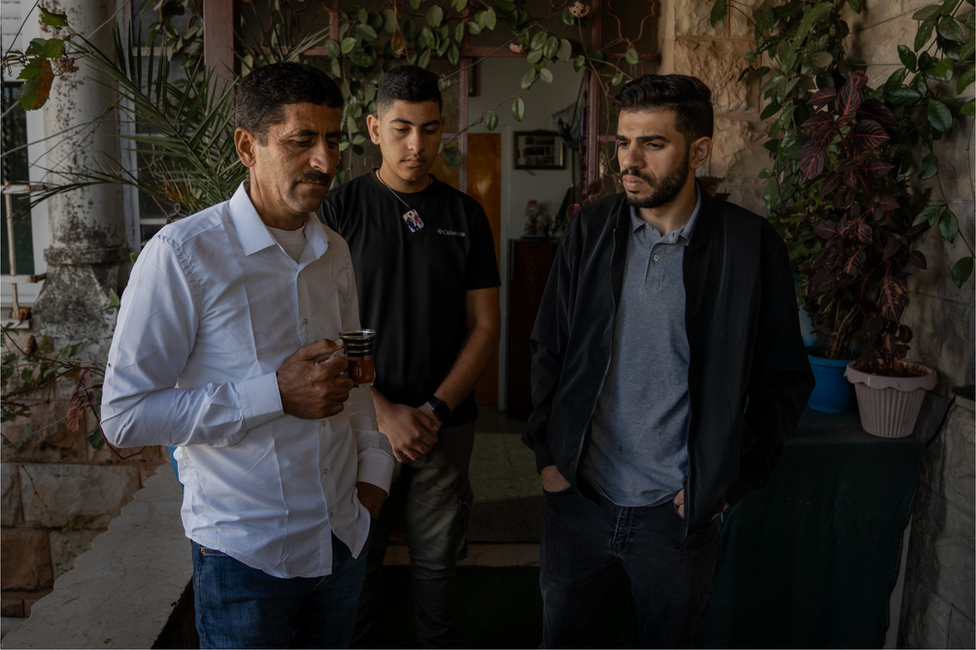 Abed Wadi, at home with his cousin Abdel Wadi, centre, and nephew Mahmoud Wadi, whose father was killed last week