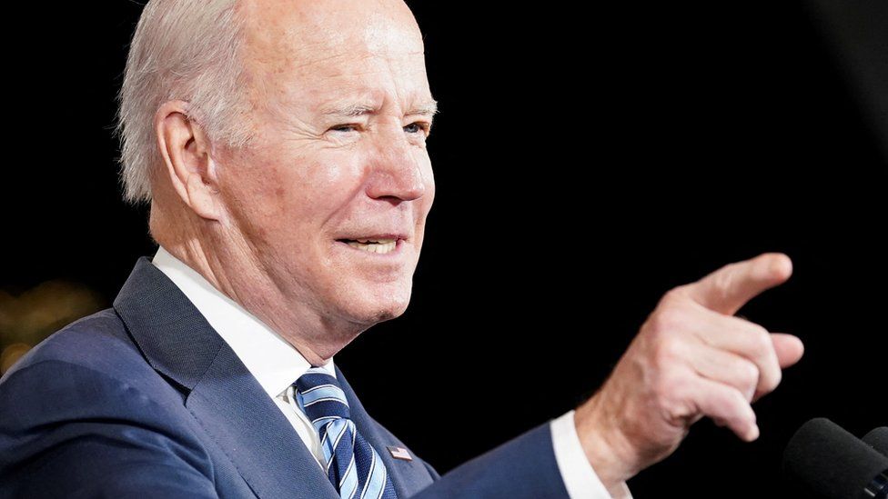 Joe Biden points to something out of frame