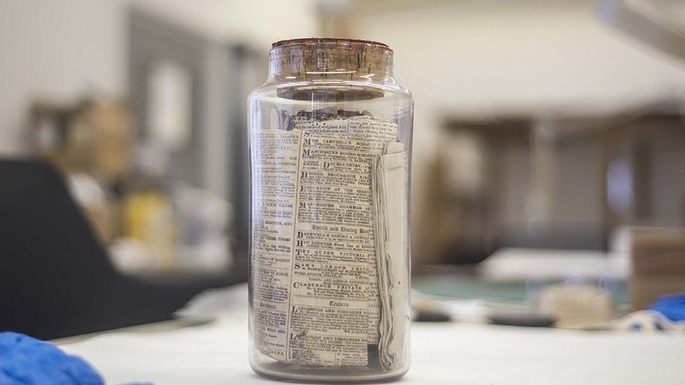 Glass jar time capsule from 1870 containing old documents and newspapers