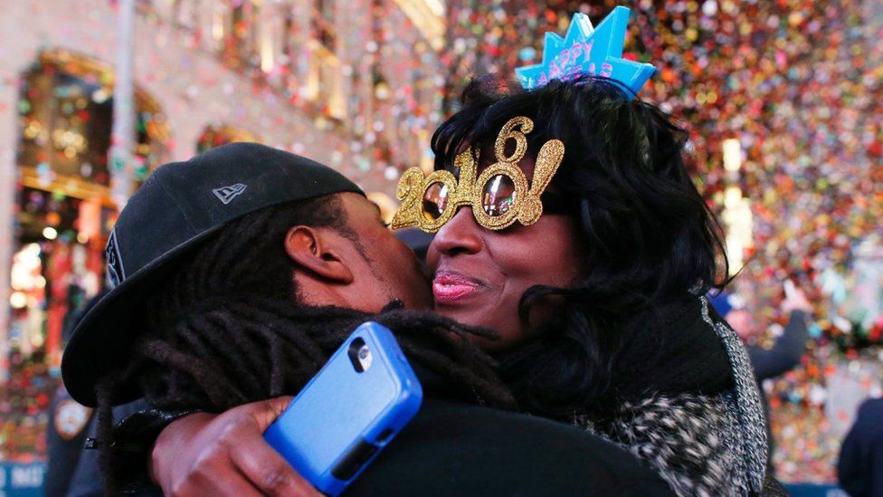 Гуляки обнимаются после падения мяча во время празднования Нового года на Таймс-сквер