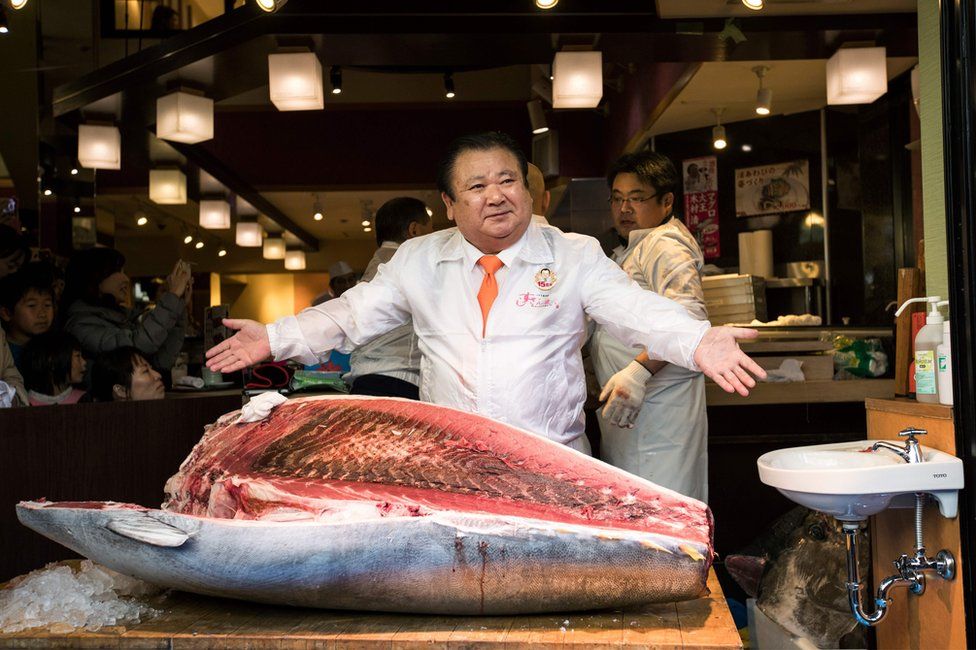 Kiyoshi Kimura, president of sushi restaurant chain Sushi-Zanmai, poses with a 212-kilogram bluefin tuna at his main restaurant near the Tsukiji fish market in Tokyo on 5 January 2017.