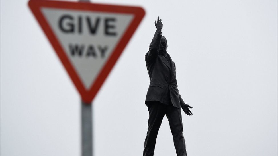 The statue of Edward Carson at Stormont next to a 'Give Way' road sign