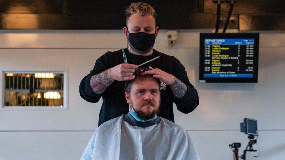 Man getting haircut at station