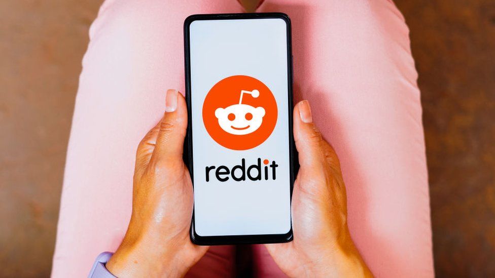 a person looks at reddit app on a phone