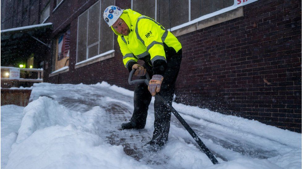 A worker shovels snow