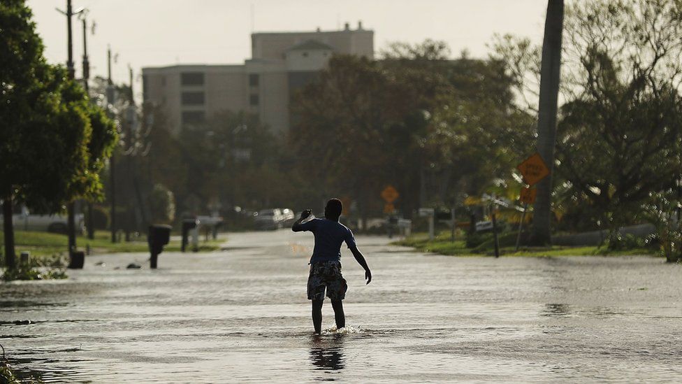 A teen walks through flooded streets the morning after Hurricane Irma swept through the area on September 11, 2017 in Naples, Florida