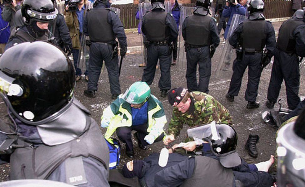 RUC officers shielding an injured colleague during the Holy Cross dispute