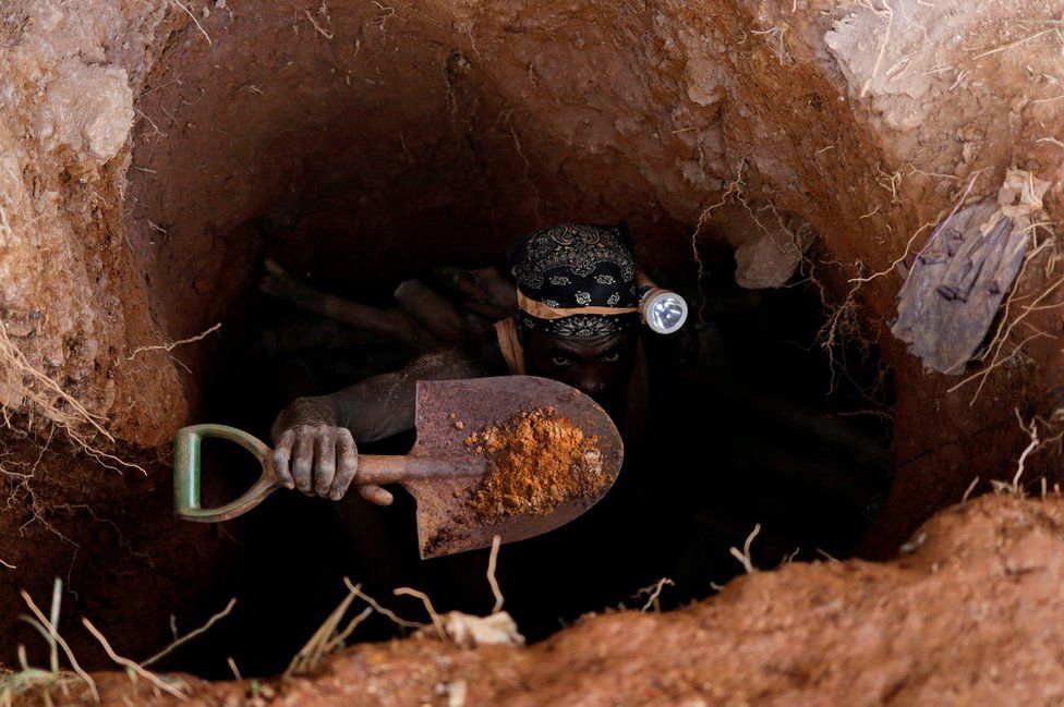 A man emerges from a gold mining pit in Nsuaem-Top, Ghana