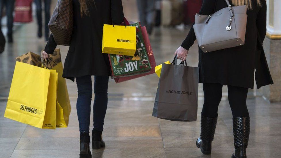 Shoppers carry bags in the Trafford Centre