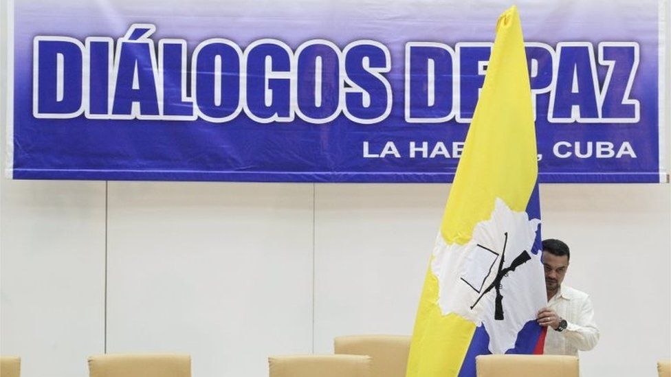A man puts up a Farc flag up before a news conference in Havana on 23 September, 2015.