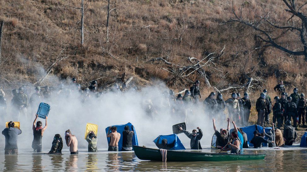 Police use pepper spray against people standing in the water of a river during a protest against the building of a pipeline on the Standing Rock Indian Reservation near Cannonball, North Dakota, Nov 2, 2016