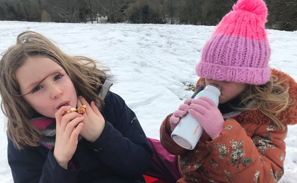 Mollie and Nell having a snack while having fun in the snow