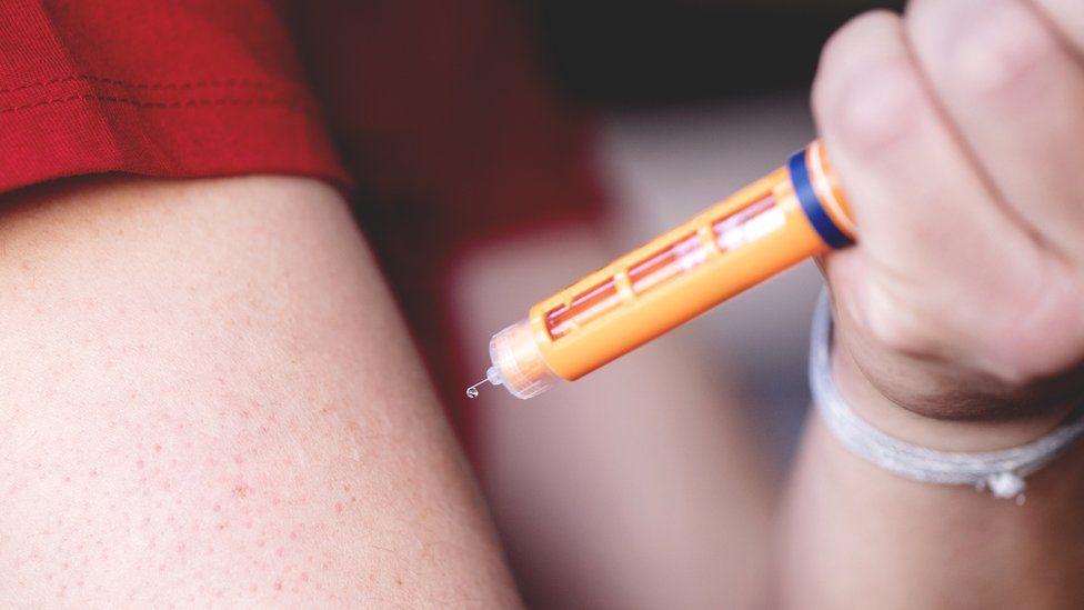 Patient using an allergy pen