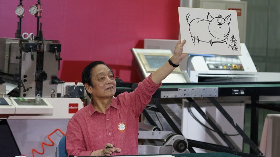 Designer Han Meilin shows off one of his designs for the stamps.