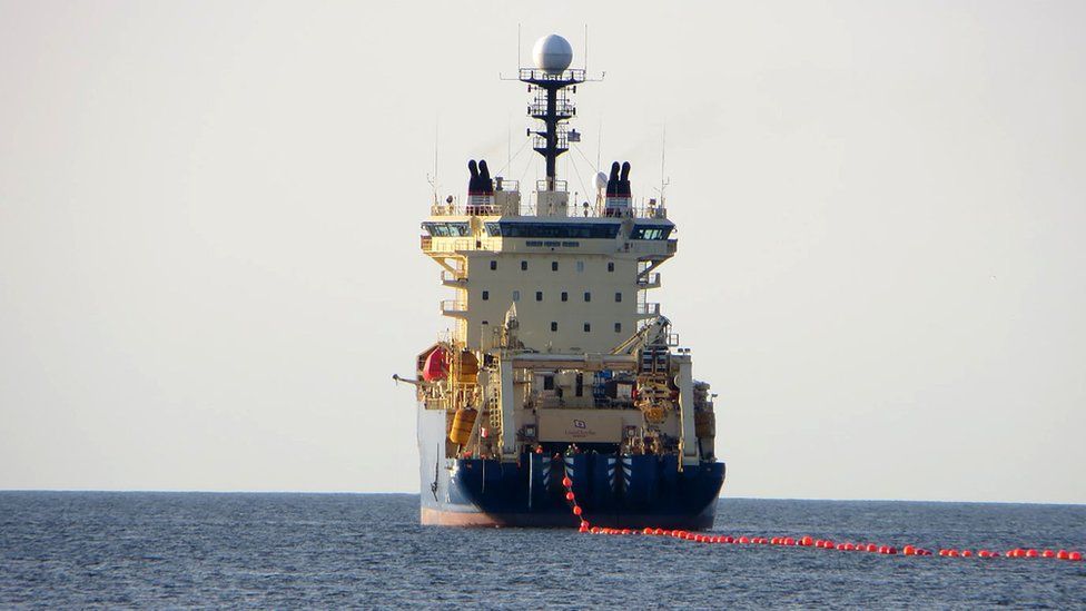 A ship dragging a cable