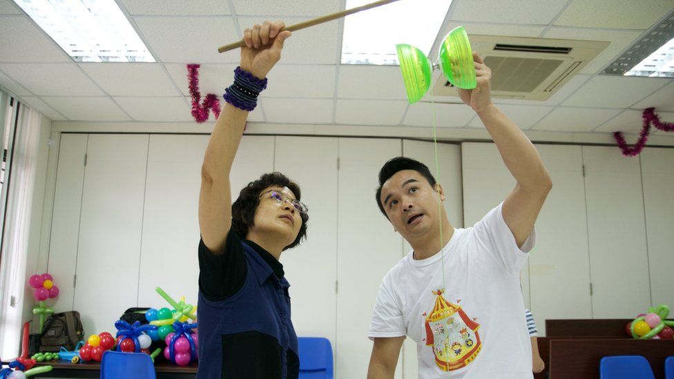 Kenneth Ng helps student Eva Yuen learn a new trick