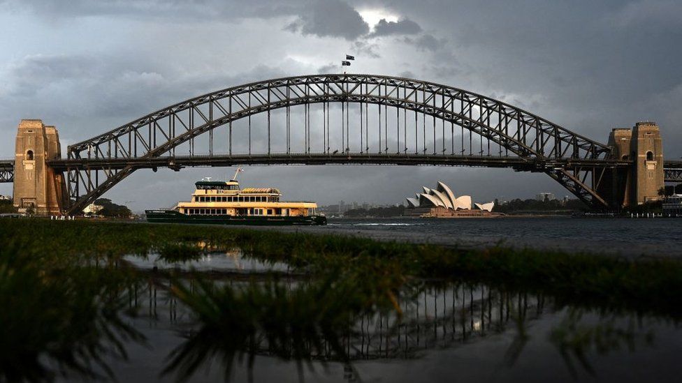A public ferry makes its way across Sydney Harbour during thundery weather in Sydney
