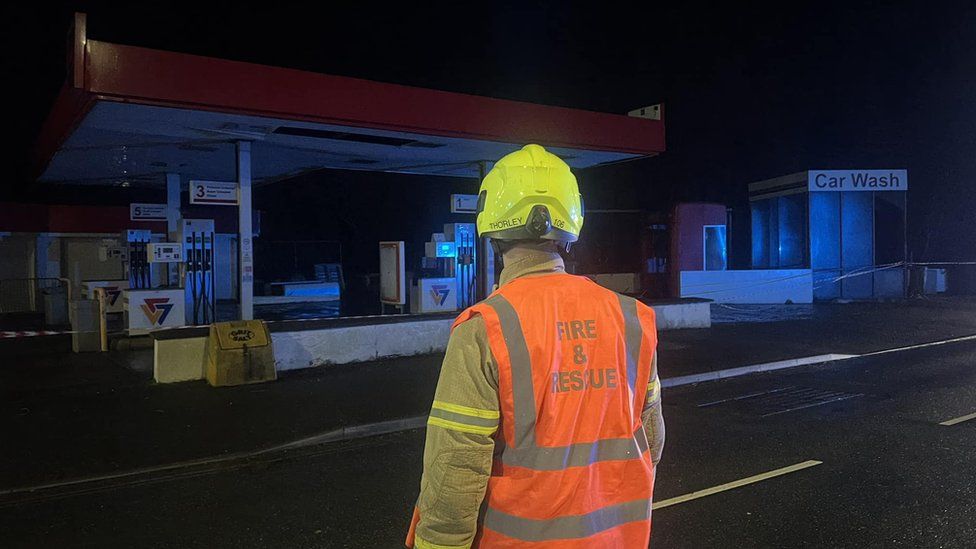Fire service officer in front of Brown Bobby filling station