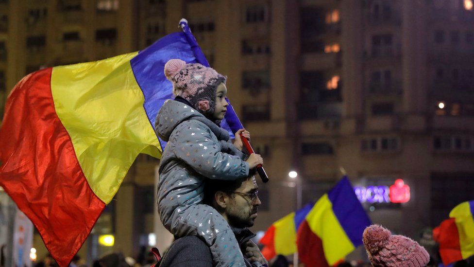 A child carries a Romanian national flag during a demonstration in Bucharest, Romania, 5 February